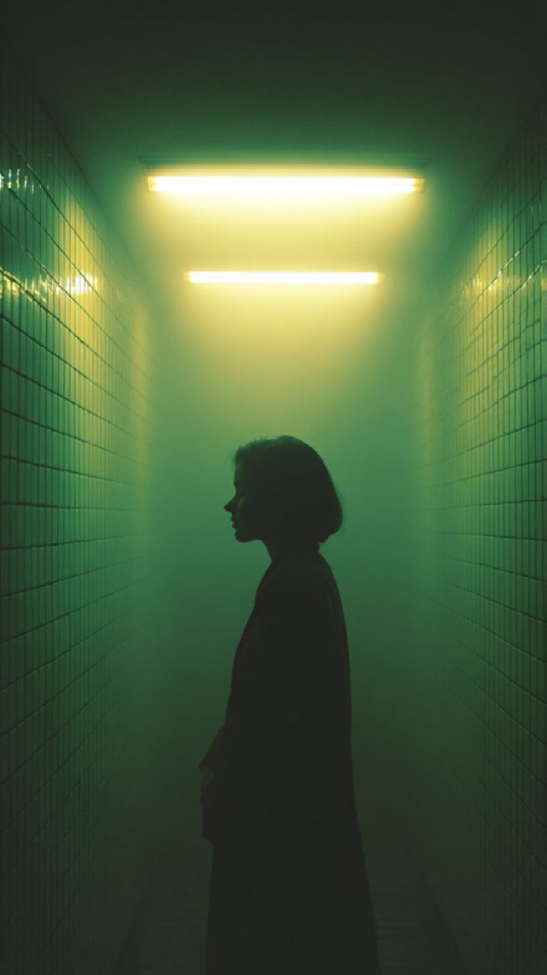 Silueta en un corredor bañado en luz verde neón.