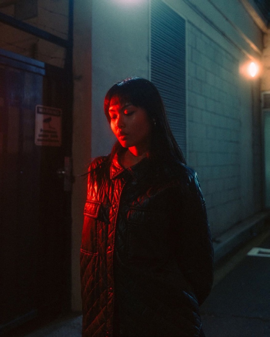 Retrato nocturno en un callejón con luz roja.
